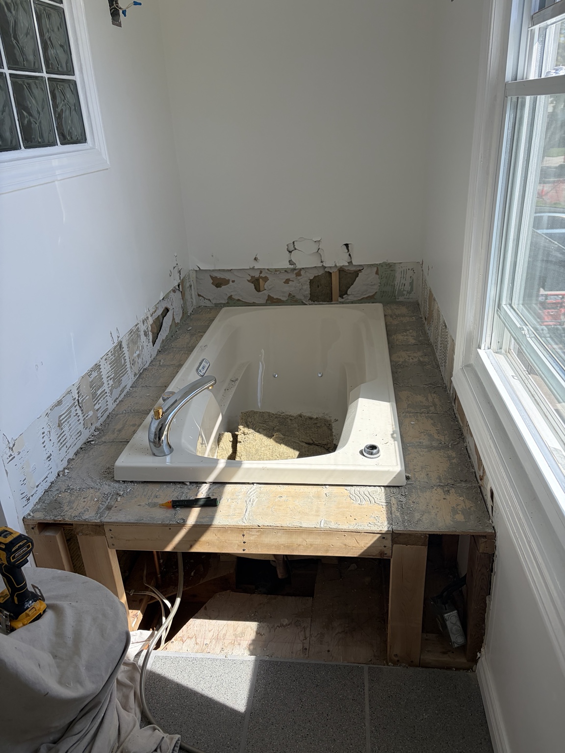 Tiled tub platform and wall finishes partly removed during demolition