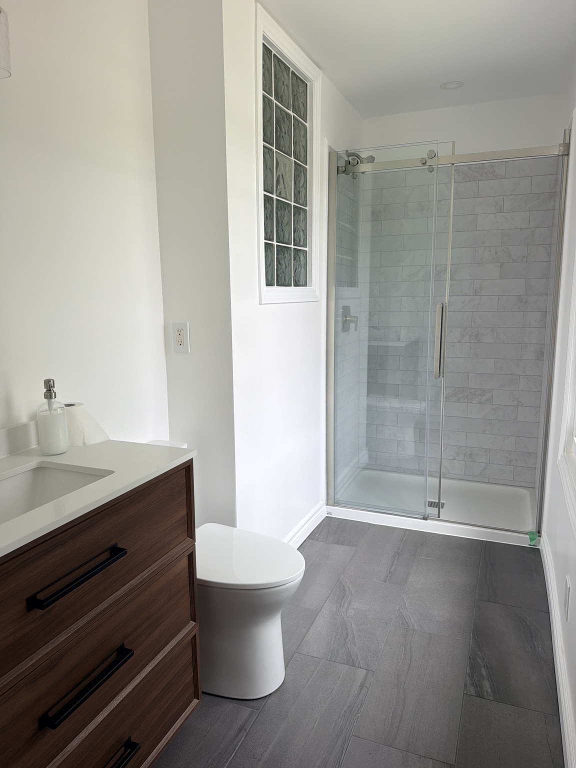 Completed tub-to-shower bathroom conversion with glass enclosure