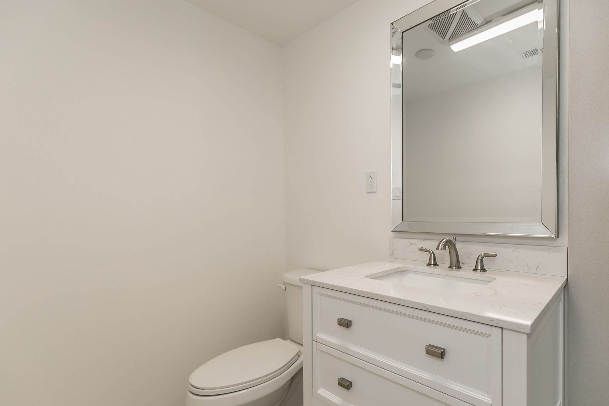 Completed Hilltop basement bathroom white vanity and mirror
