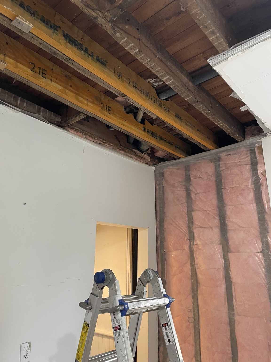 Opened wall and ceiling with insulation exposed during renovation
