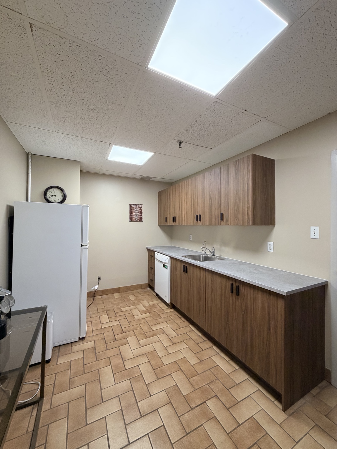 Completed kitchenette with walnut-look cabinets and gray counter