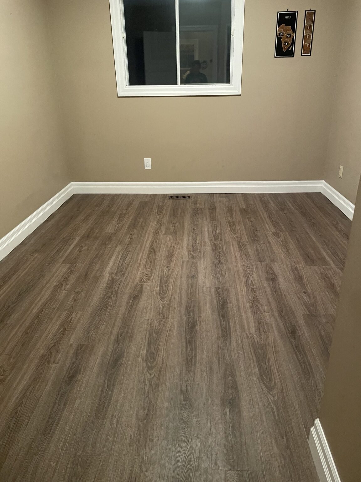 Completed Medway room with cool gray-brown plank flooring and finished baseboards