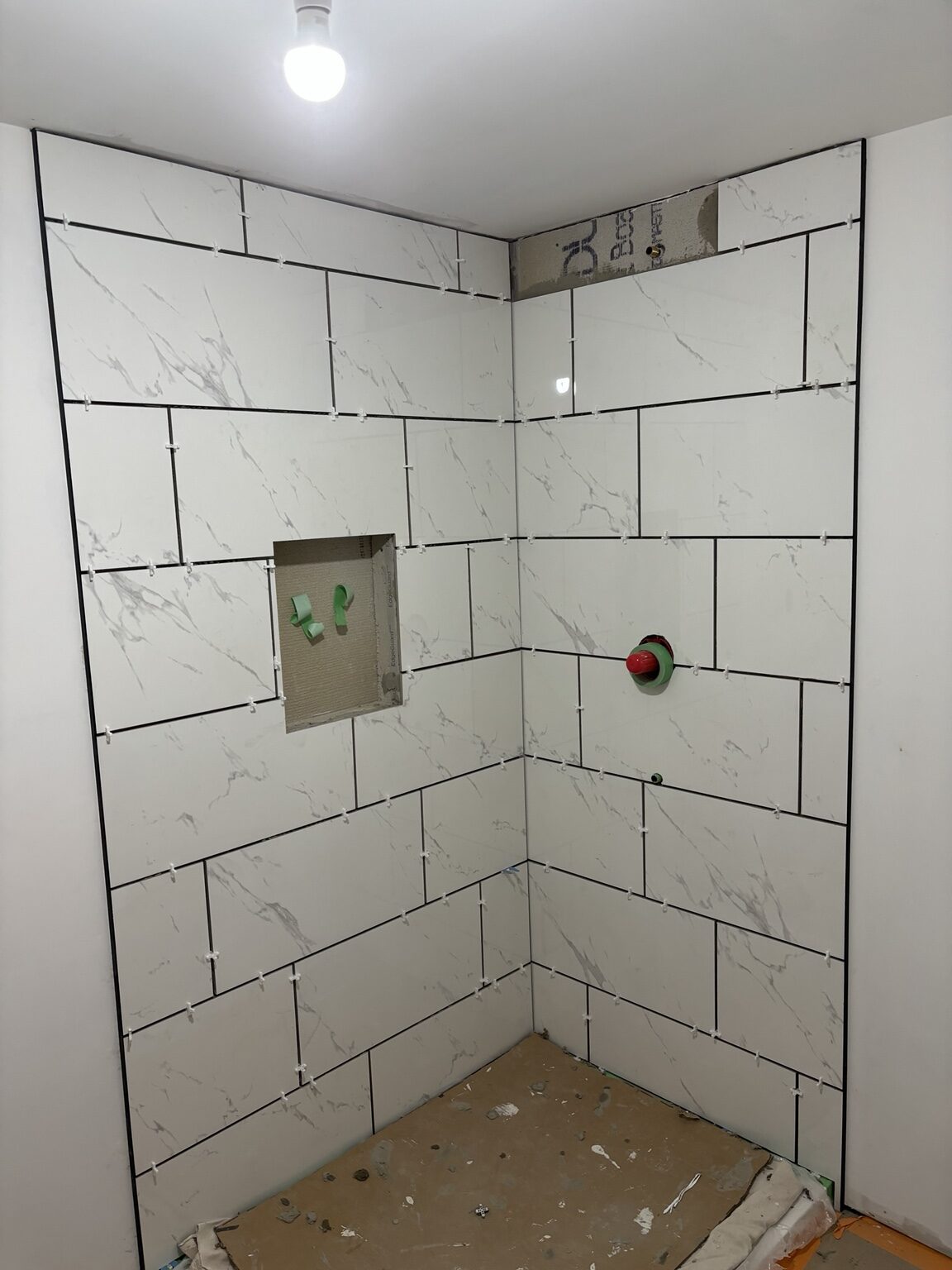 Dark wall tile being installed in the Melrose-area shower