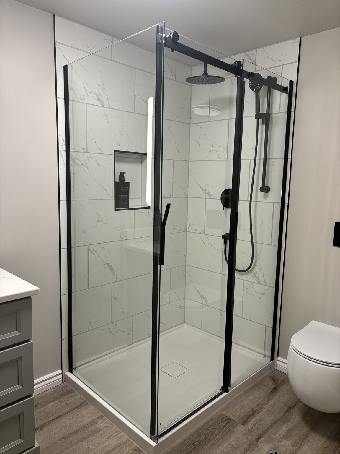 Completed Melrose-area tiled shower and wall-hung toilet