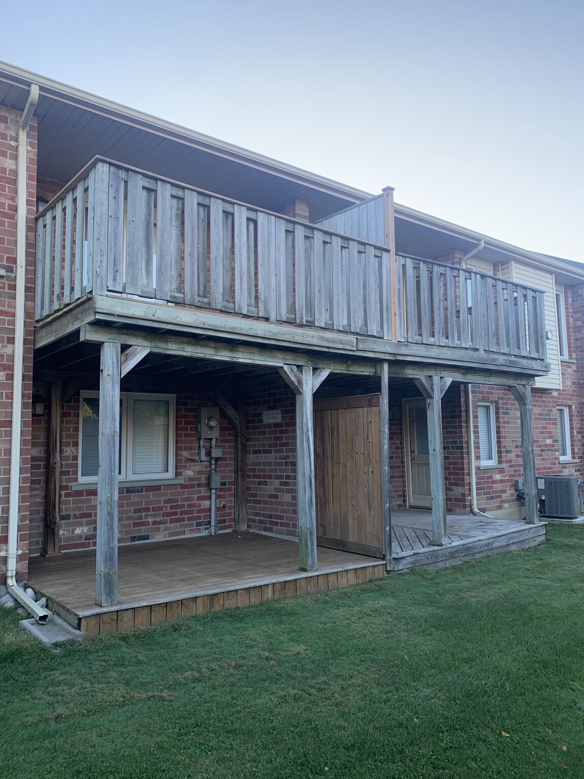 Weathered elevated wood decks at an anonymous multi-unit property before renewal