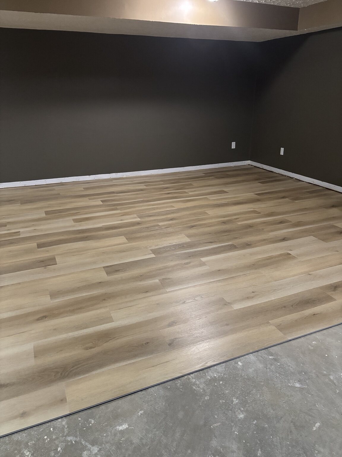 Pond Mills lower-level flooring nearly complete before threshold and baseboard finishing