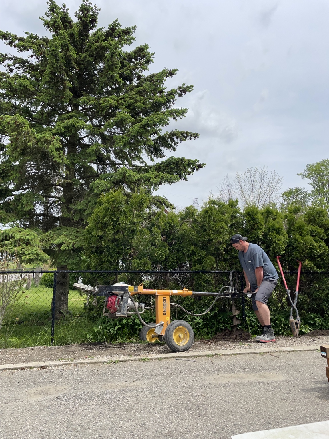 Powered auger digging a post hole
