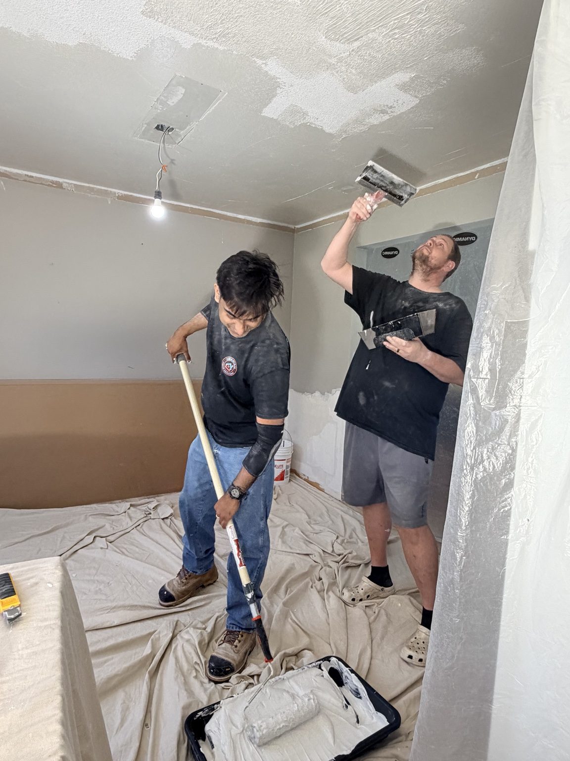 Ceiling skim coating underway in a protected room