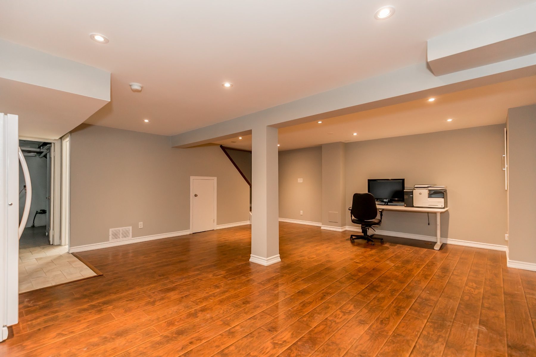 Finished basement living space with warm wood flooring