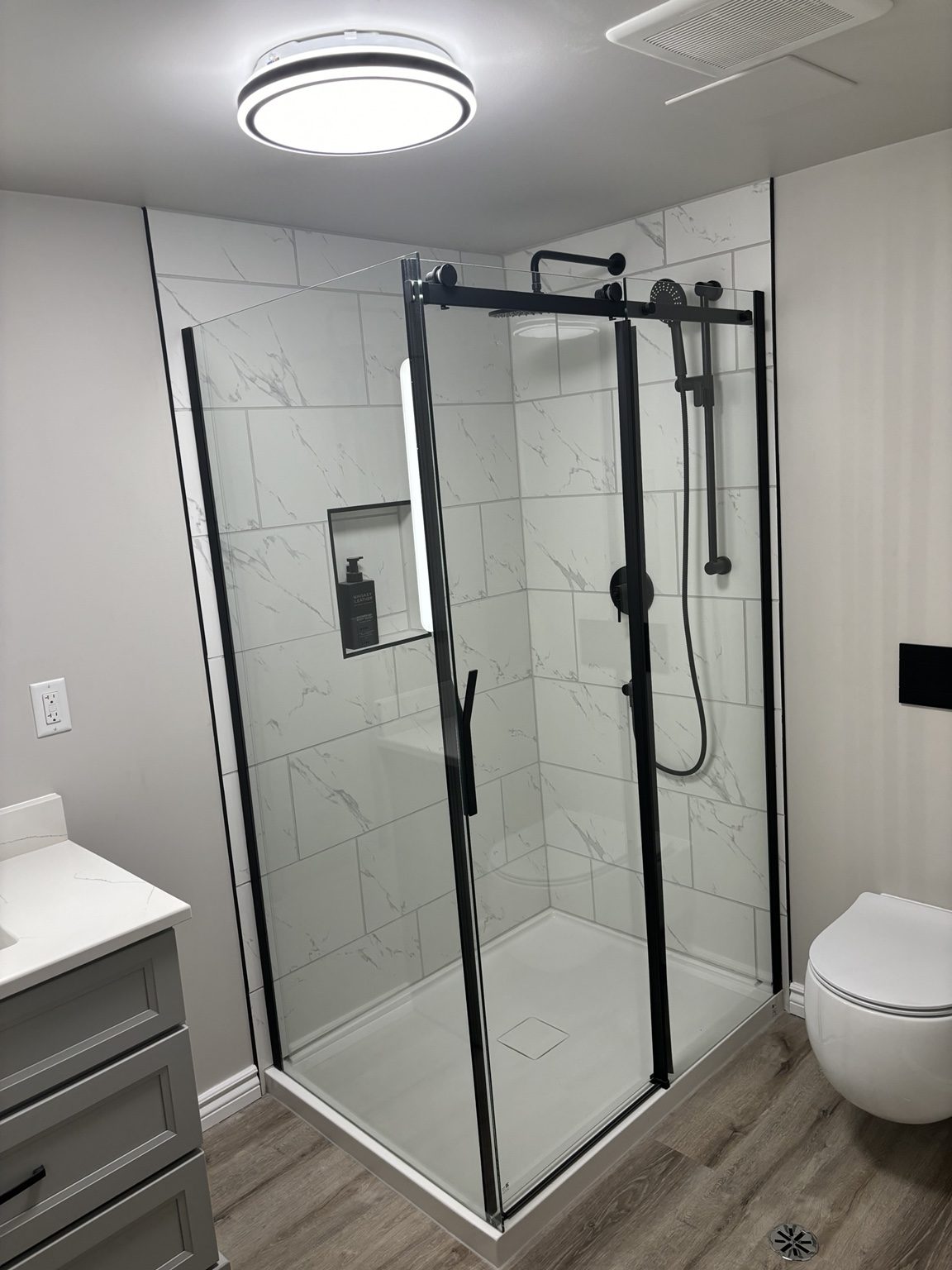 Completed bathroom with glass shower enclosure