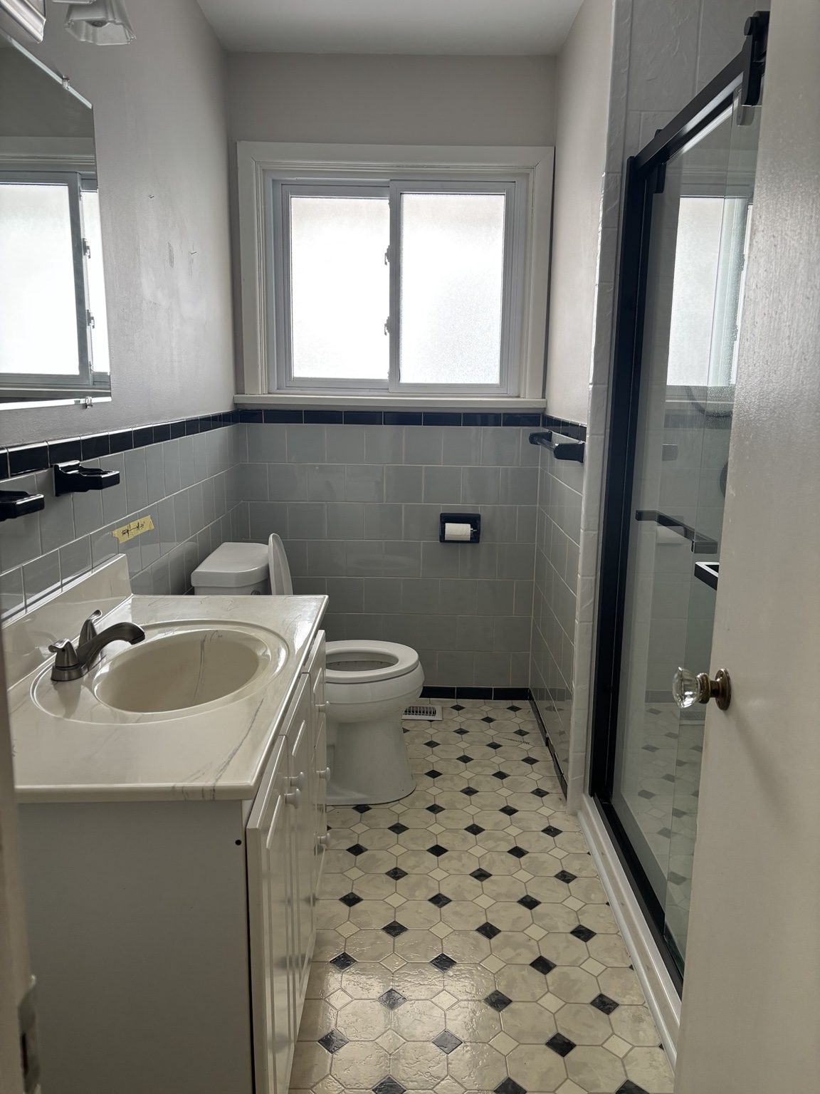 Frosted-window bathroom before wall and floor repair