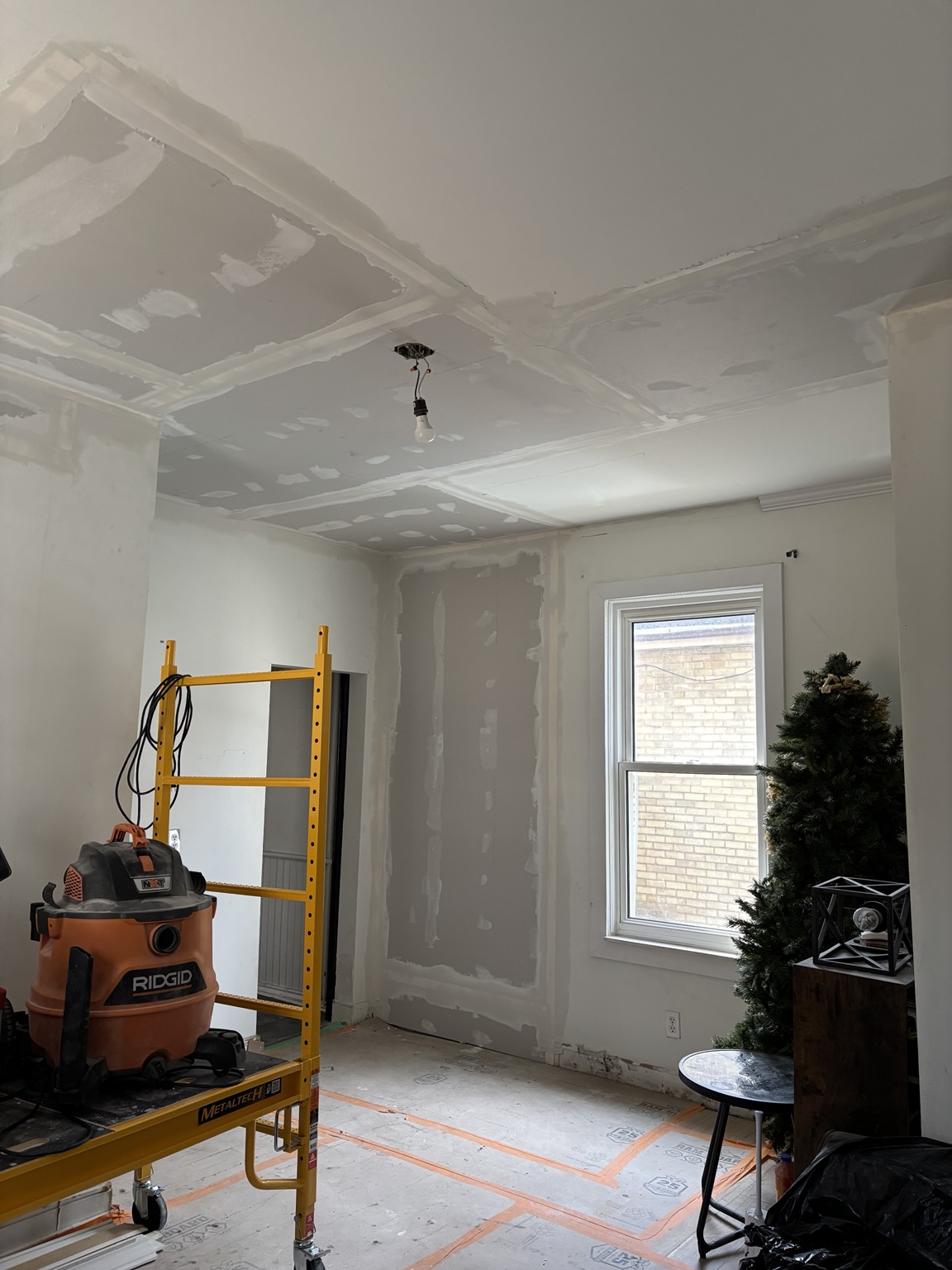 Ceiling and wall surfaces being rebuilt with new drywall and compound