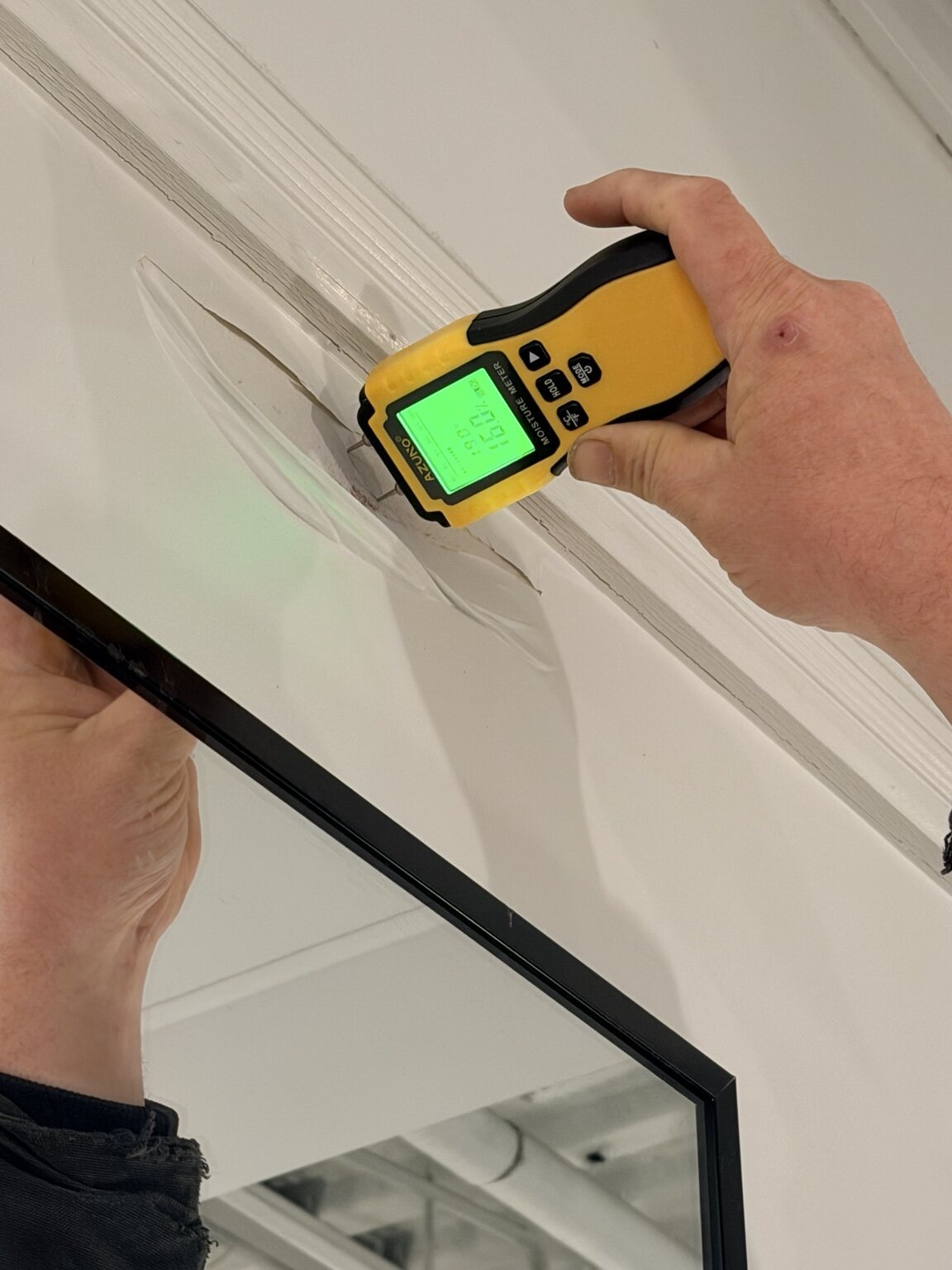 Moisture meter documenting the affected trim area in an anonymous London salon